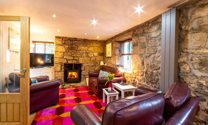 Has comfortable leather seating, an oak floor and rug, a  large screen TV and an irriststible woodburner!